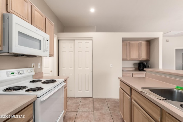 kitchen with light brown cabinets, sink, light tile patterned floors, and white appliances