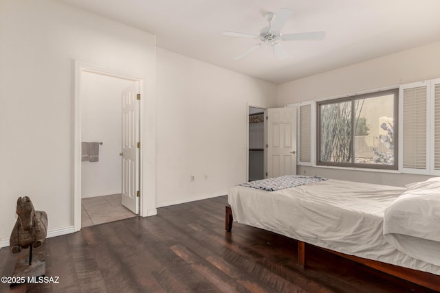 bedroom with a spacious closet, connected bathroom, and dark hardwood / wood-style flooring