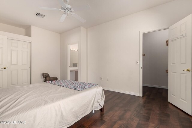 bedroom featuring dark hardwood / wood-style flooring, connected bathroom, and ceiling fan