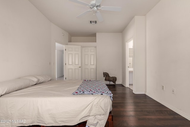bedroom with dark wood-type flooring, connected bathroom, ceiling fan, and a closet