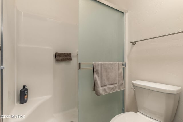 bathroom featuring toilet and walk in shower