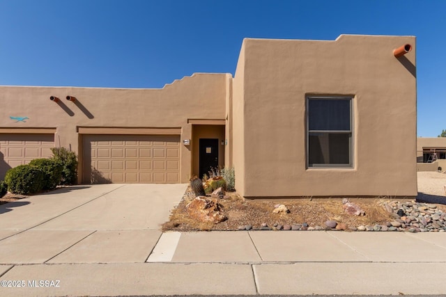 pueblo revival-style home with a garage