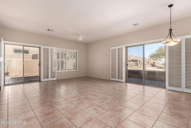 tiled spare room featuring ceiling fan