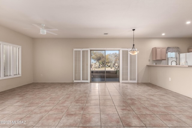 interior space with sink, light tile patterned floors, and ceiling fan