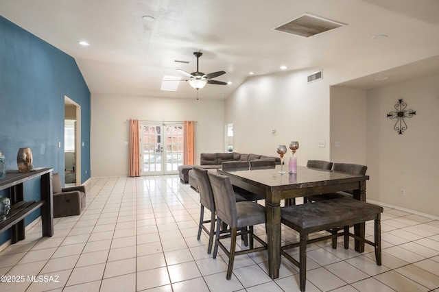 tiled dining area with ceiling fan, vaulted ceiling, and a healthy amount of sunlight