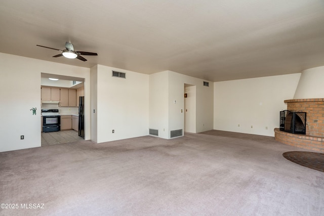 unfurnished living room featuring ceiling fan, light carpet, and a fireplace