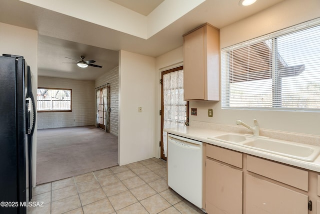 kitchen with sink, black refrigerator with ice dispenser, light carpet, white dishwasher, and brick wall