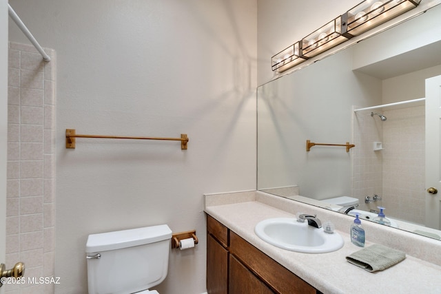 full bathroom featuring tiled shower / bath, vanity, and toilet