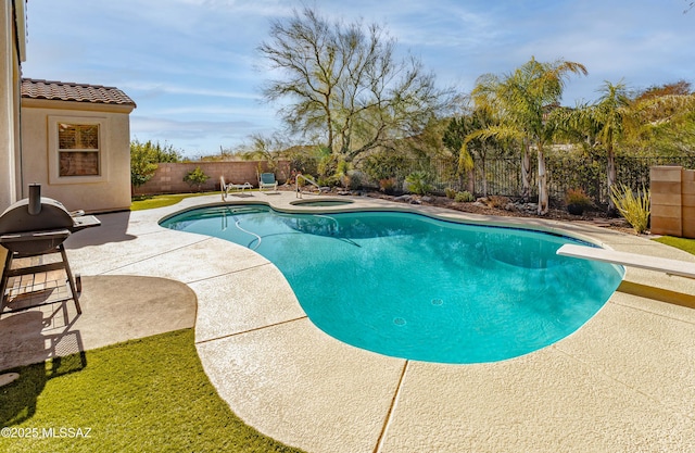 view of pool with area for grilling, a patio, a diving board, and an in ground hot tub