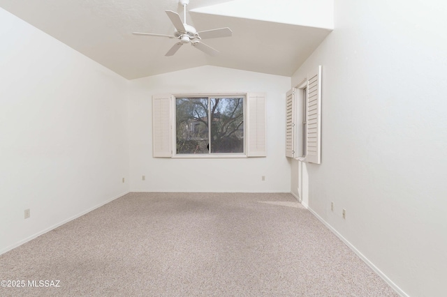 carpeted spare room featuring ceiling fan and vaulted ceiling