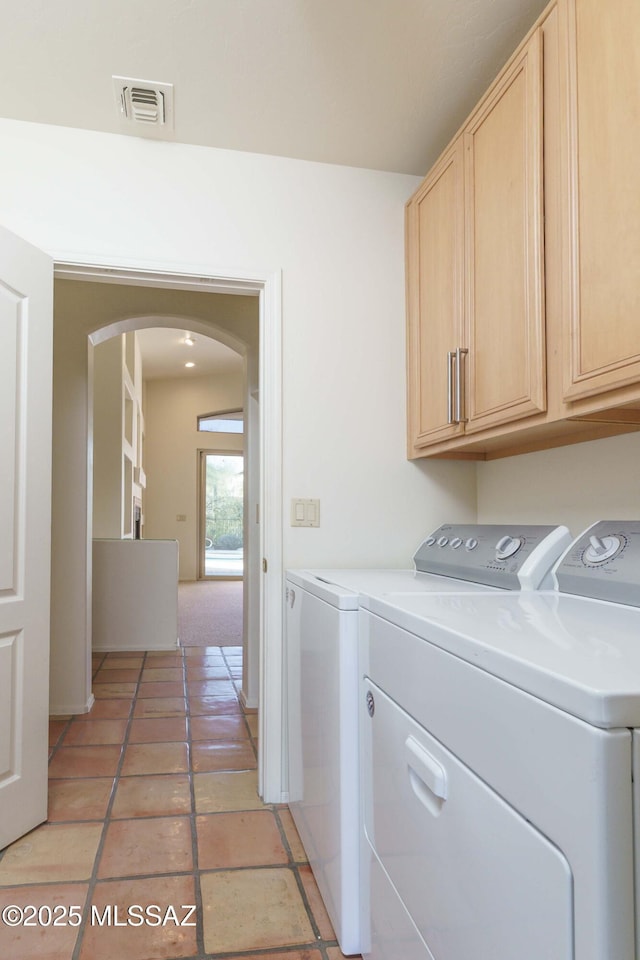 laundry area featuring independent washer and dryer, cabinets, and tile patterned floors