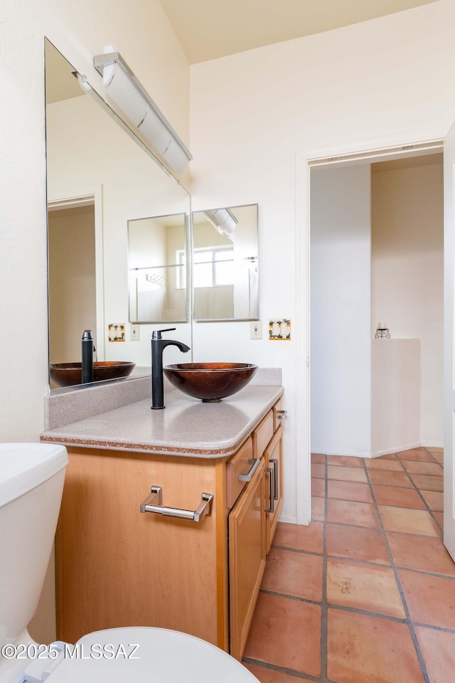 bathroom with tile patterned flooring, vanity, and toilet