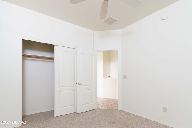 unfurnished bedroom with light carpet, a closet, and ceiling fan