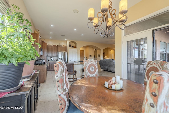 tiled dining room featuring a chandelier