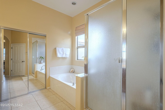 bathroom with independent shower and bath and tile patterned flooring