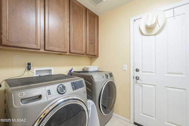 laundry area featuring washer and clothes dryer and cabinets