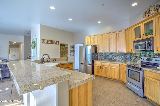 kitchen featuring tasteful backsplash, appliances with stainless steel finishes, sink, and a center island with sink