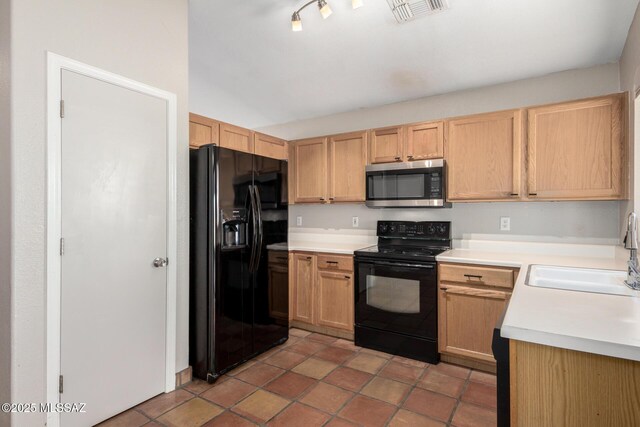 kitchen featuring dark tile patterned floors, sink, light brown cabinetry, and black appliances