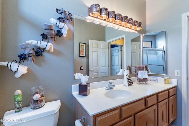 bathroom with vanity, an enclosed shower, and toilet