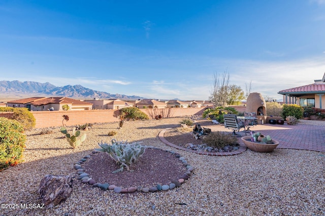 view of yard featuring a mountain view, a patio, and a multi sided fireplace