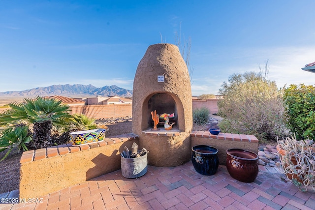 view of patio / terrace with exterior fireplace and a mountain view