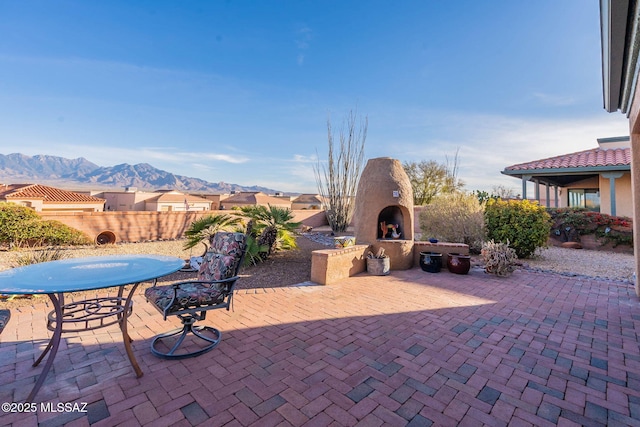 view of patio featuring an outdoor fireplace and a mountain view