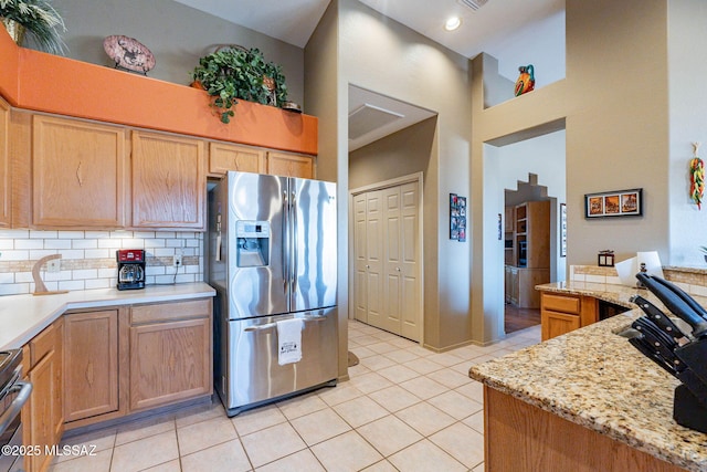 kitchen with tasteful backsplash, stainless steel appliances, and light tile patterned flooring