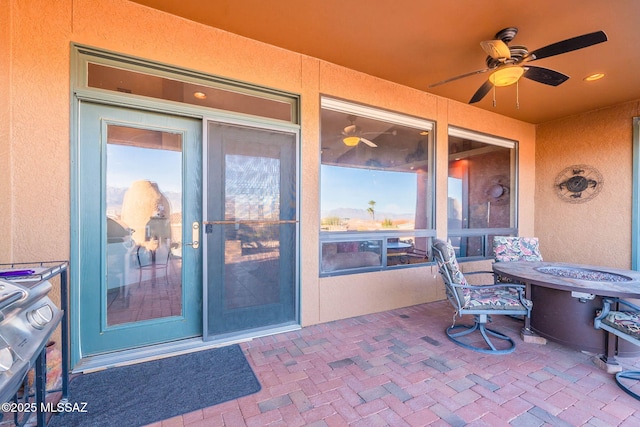 view of patio featuring ceiling fan and an outdoor fire pit