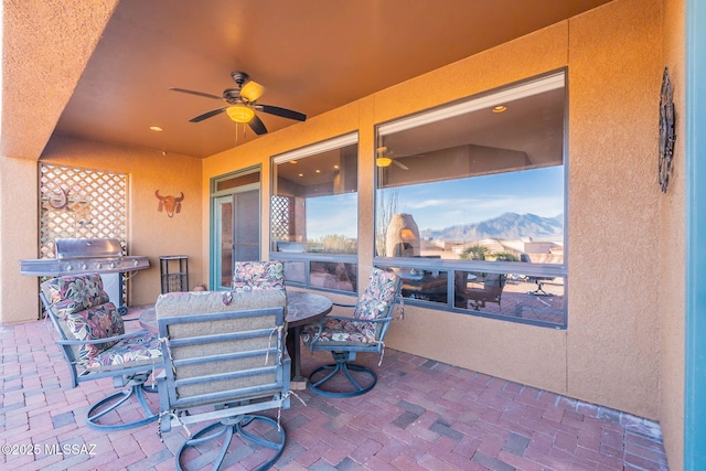 view of patio featuring ceiling fan, grilling area, and a mountain view