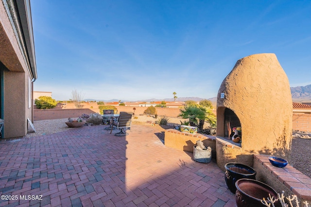 view of patio featuring a mountain view and exterior fireplace