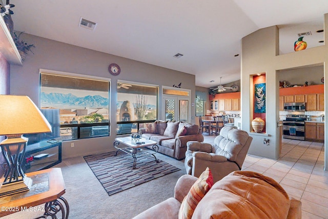 living room with light tile patterned flooring, ceiling fan, and lofted ceiling