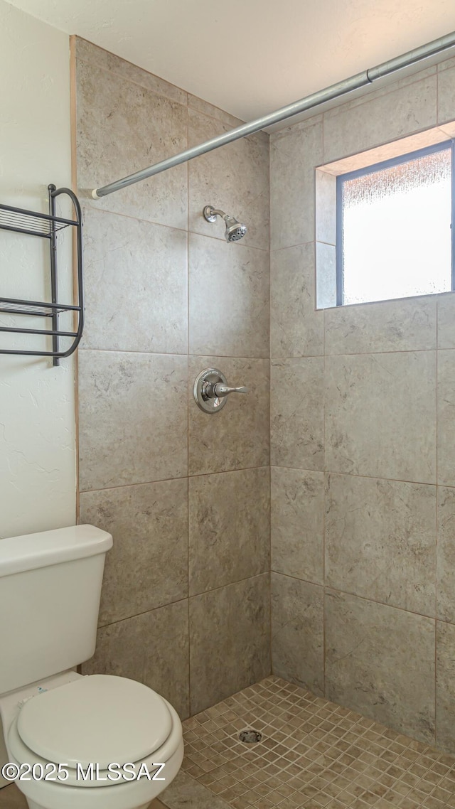 bathroom with tiled shower and toilet