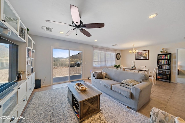 tiled living room featuring ceiling fan with notable chandelier