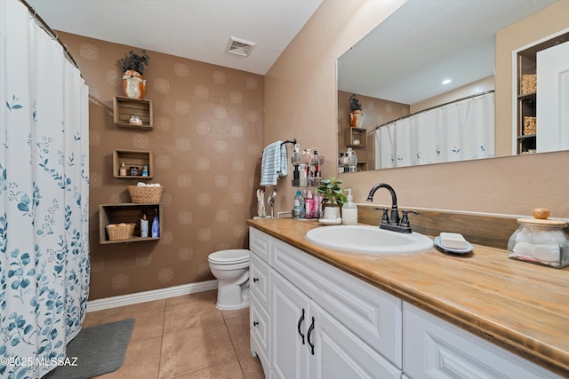 bathroom with vanity, tile patterned floors, and toilet