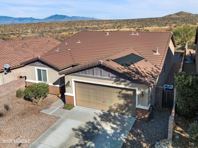 ranch-style house with a mountain view, a garage, and central AC