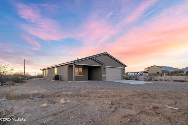 view of front of property featuring cooling unit and a garage