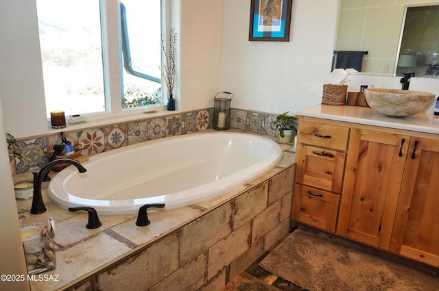 bathroom featuring vanity and tiled tub