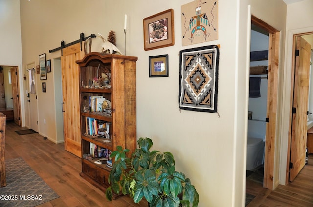 hall featuring dark hardwood / wood-style flooring and a barn door