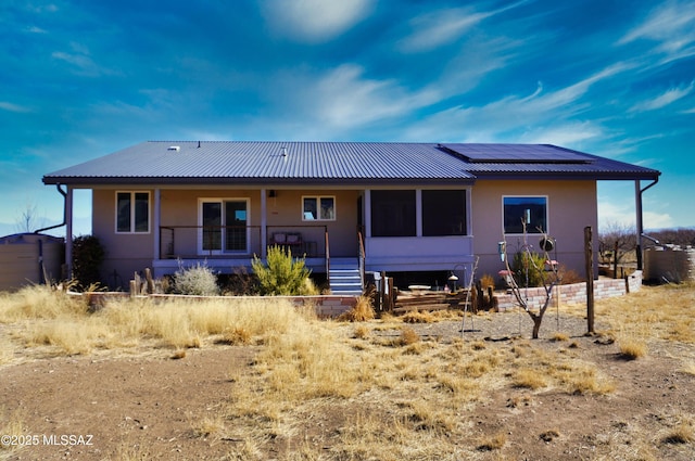 back of house with solar panels and covered porch