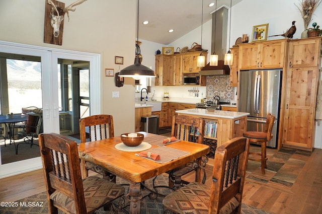 dining space with sink, high vaulted ceiling, dark hardwood / wood-style floors, and french doors