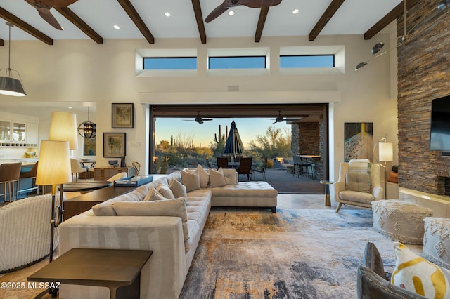 living room featuring beam ceiling, a towering ceiling, and ceiling fan