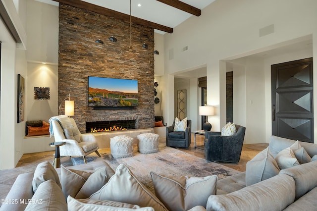 living room with beamed ceiling, a towering ceiling, and a stone fireplace