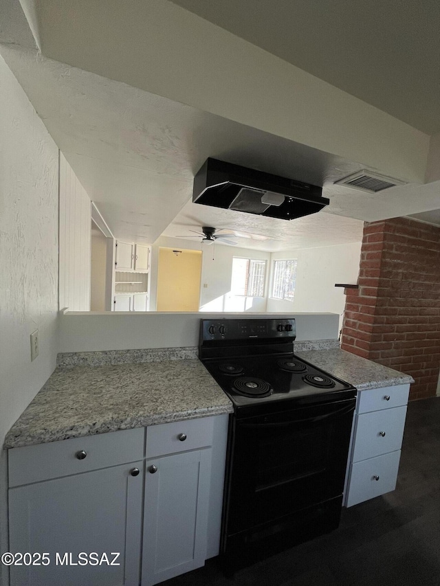 kitchen with brick wall, range hood, white cabinetry, ceiling fan, and black electric range