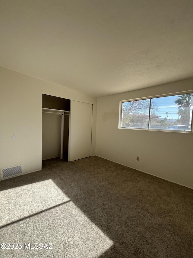 unfurnished bedroom with a closet and carpet flooring