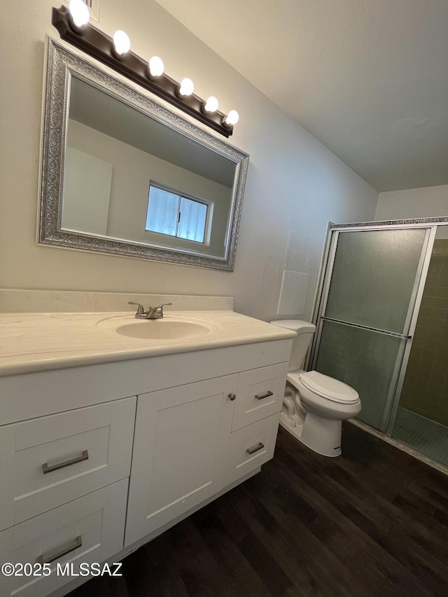 bathroom with a shower with door, wood-type flooring, vanity, and toilet