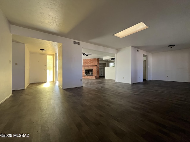 unfurnished living room with dark hardwood / wood-style flooring, a fireplace, and ceiling fan