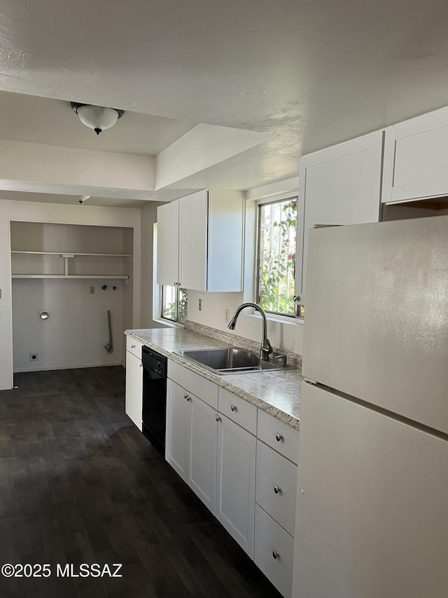 kitchen featuring sink, dark hardwood / wood-style flooring, black dishwasher, white fridge, and white cabinets