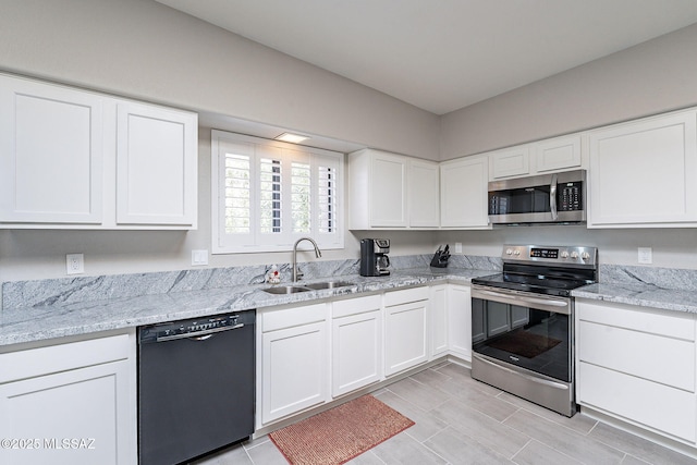 kitchen featuring light stone counters, sink, white cabinets, and appliances with stainless steel finishes