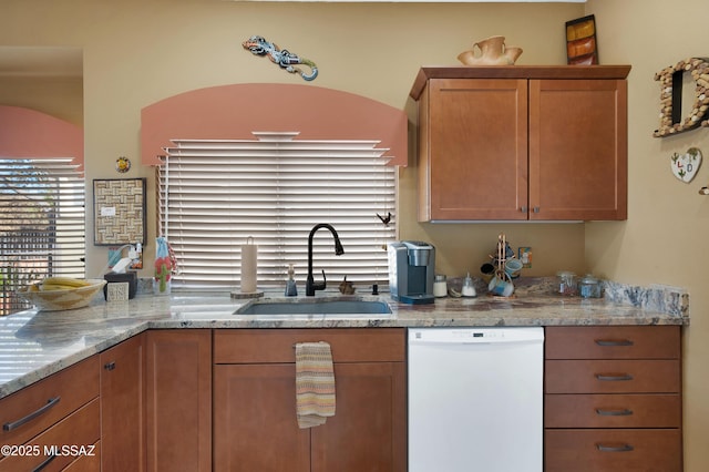 kitchen with light stone counters, sink, and dishwasher