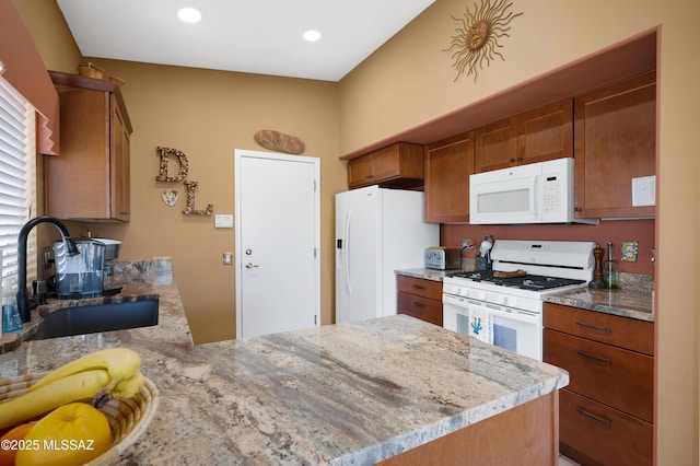 kitchen featuring white appliances, kitchen peninsula, sink, and light stone countertops